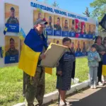 Олександр Сичов знімає свою фотокартку з Алеї Надії у Великоолександрівській громаді після повернення з полону