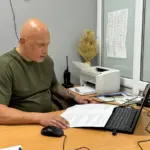 Група дітей, які посміхаються та тримаються за руки, на тлі державного прапора України
