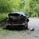 Пошкоджений автомобіль після атаки російського дрона у центрі Херсона, поруч працюють медики