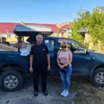 Жінка похилого віку, яка евакуюється з небезпечної зони, їй допомагають волонтери.