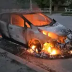 Пошкоджений автомобіль після атаки дрона в Херсоні, чоловік та жінка отримують допомогу