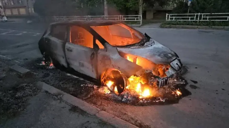 Пошкоджений автомобіль після атаки дрона в Херсоні, чоловік та жінка отримують допомогу