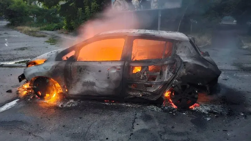 Пошкоджений автомобіль після атаки дрона в Херсоні, чоловік та жінка отримують допомогу 1