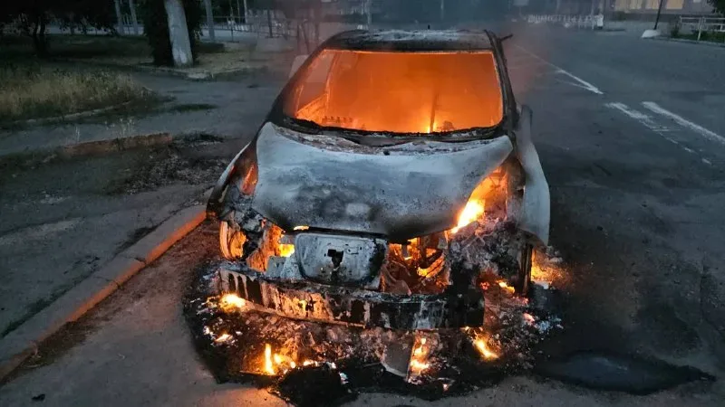 Пошкоджений автомобіль після атаки дрона в Херсоні, чоловік та жінка отримують допомогу 2