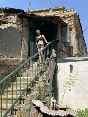 Зруйнований будинок у Херсоні після обстрілів, жінка тримає в руках документи 1