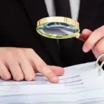Схематичне зображення аудиту, перевірки документів та фінансів на тлі символіки Херсонської ОВА.