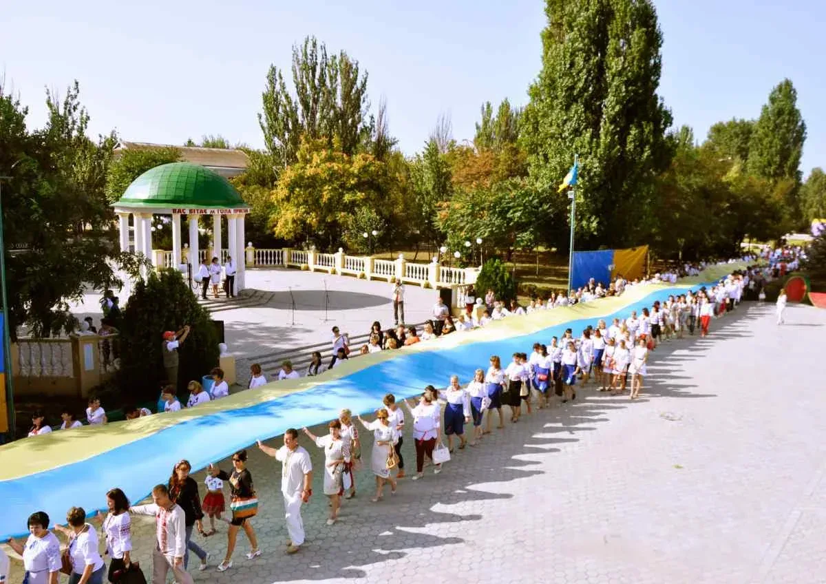 Літня жінка на тлі пошкоджених будівель у Голій Пристані 1