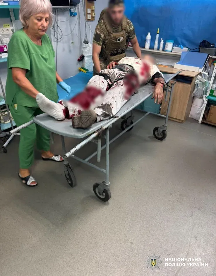 Поліцейські спецпідрозділу надають домедичну допомогу пораненому чоловіку після атаки дрона в Херсоні. 5