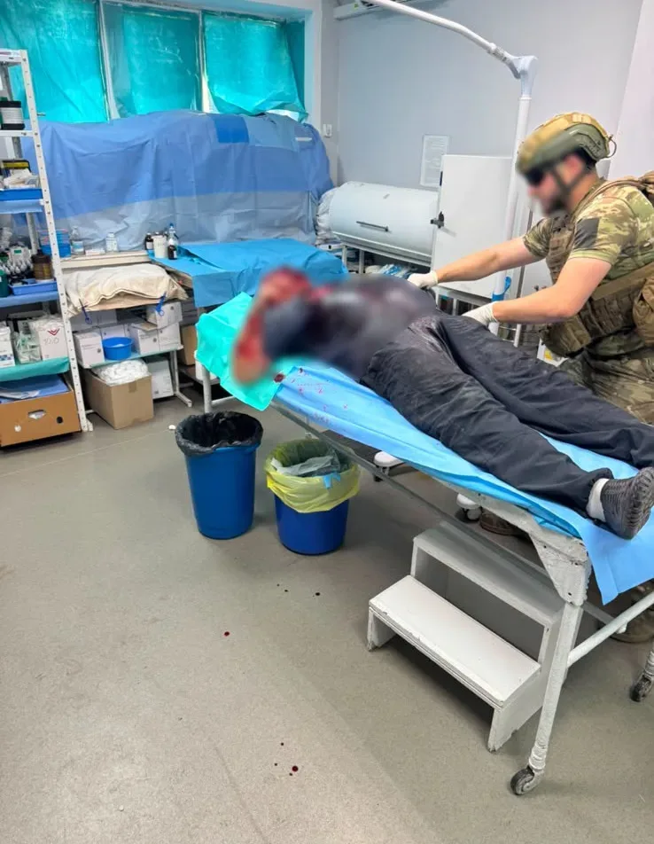 Поліцейські спецпідрозділу надають домедичну допомогу пораненому чоловіку після атаки дрона в Херсоні. 6