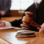 Символічне зображення правосуддя з терезами на фоні Херсонщини, що ілюструє заочний судовий процес.