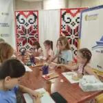 Діти переселенців з Херсонщини в Одесі під час майстер-класу розфарбовують фігурки.