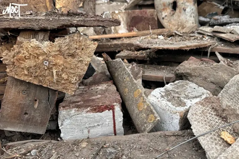 Літній чоловік з перев'язаними частинами тіла сидить на балконі зруйнованого будинку в Херсоні після авіаудару