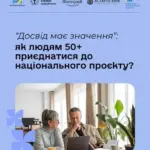 Літня людина сидить за столом, користуючись ноутбуком, посміхається, можливо, шукає роботу онлайн