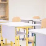 Діти, що навчаються дистанційно, з ноутбуками на фоні карти України та прапора Херсонської області