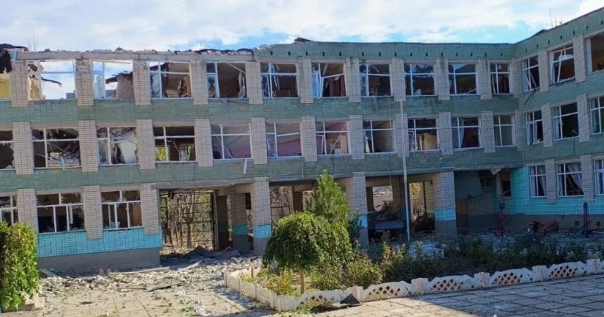 Жінка тримає в руках документ про освіту на фоні зруйнованого Херсона 2