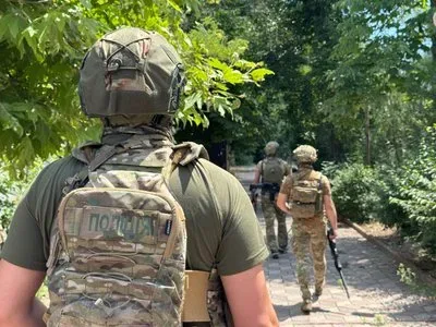 Поліцейський готується до збиття ворожого дрона в Херсоні, на фоні пошкоджених будівель 3