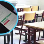 Учень на НМТ під час складання тесту, концентровано пише відповіді на папері, поруч стоїть викладач 3