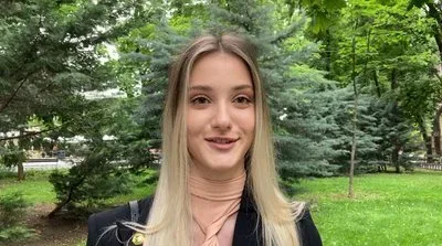 Учень на НМТ під час складання тесту, концентровано пише відповіді на папері, поруч стоїть викладач 1