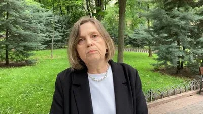 Учень на НМТ під час складання тесту, концентровано пише відповіді на папері, поруч стоїть викладач 2
