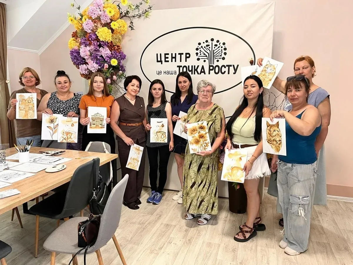 Переселенки з Херсонщини малюють кавою під час майстер-класу в Миколаєві, щоб підтримати ментальне здоров'я. 1