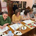 Переселенки з Херсонщини в Одесі малюють маки в техніці кавового живопису на заході, присвяченому Маковія.