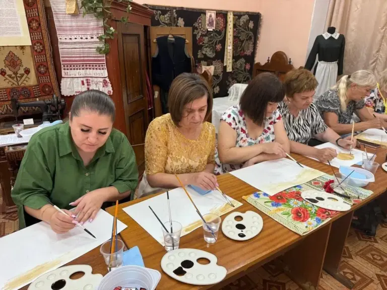 Переселенки з Херсонщини в Одесі малюють маки в техніці кавового живопису на заході, присвяченому Маковія.