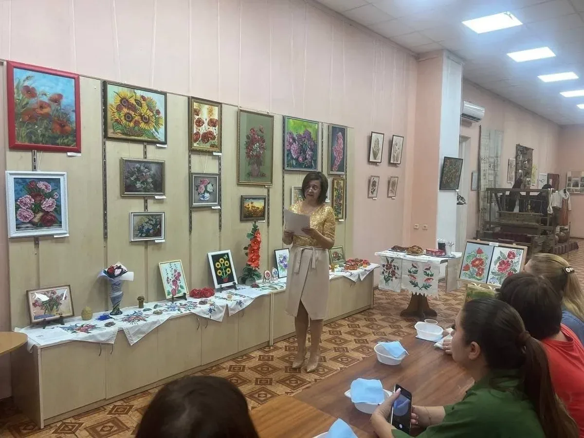 Переселенки з Херсонщини в Одесі малюють маки в техніці кавового живопису на заході, присвяченому Маковія. 1