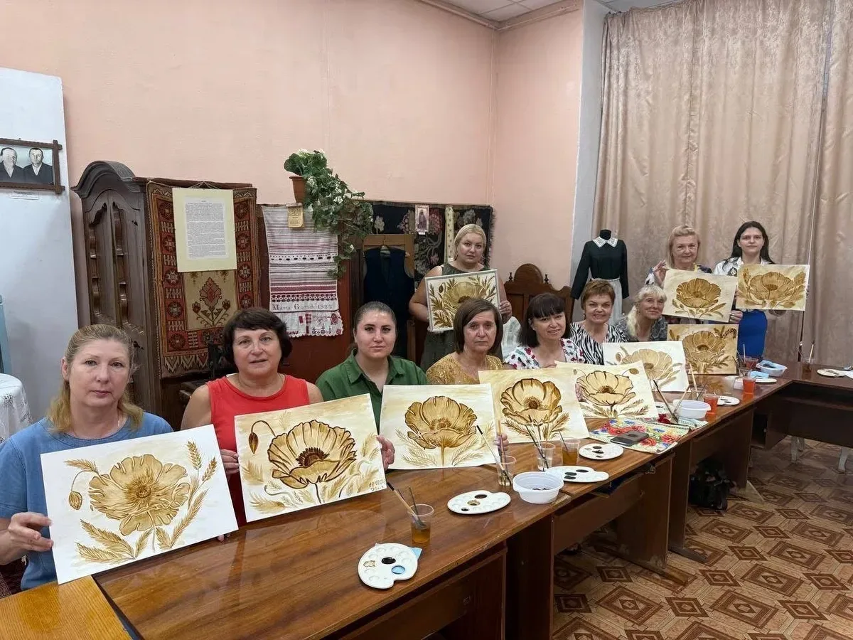 Переселенки з Херсонщини в Одесі малюють маки в техніці кавового живопису на заході, присвяченому Маковія. 3