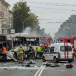 Зруйнована маршрутка після удару дроном в Центральному районі Херсона, надзвичайники працюють на місці події