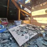 Пошкоджений будинок у Херсоні після атаки дроном, медики надають допомогу жінці