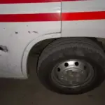 Пошкоджена карета швидкої допомоги після обстрілу в Херсоні, поруч медики надають допомогу