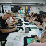 Учасники майстер-класу розписують одяг українською символікою в Херсонському Центрі життєстійкості.