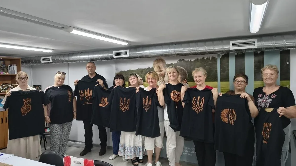 Учасники майстер-класу розписують одяг українською символікою в Херсонському Центрі життєстійкості. 1
