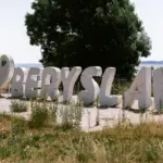 Зруйновані будинки у місті Берислав, люди стоять біля будівлі та обговорюють ситуацію.
