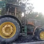 Згорілий трактор John Deere на фермерській базі після атаки російського дрона в Бериславському районі