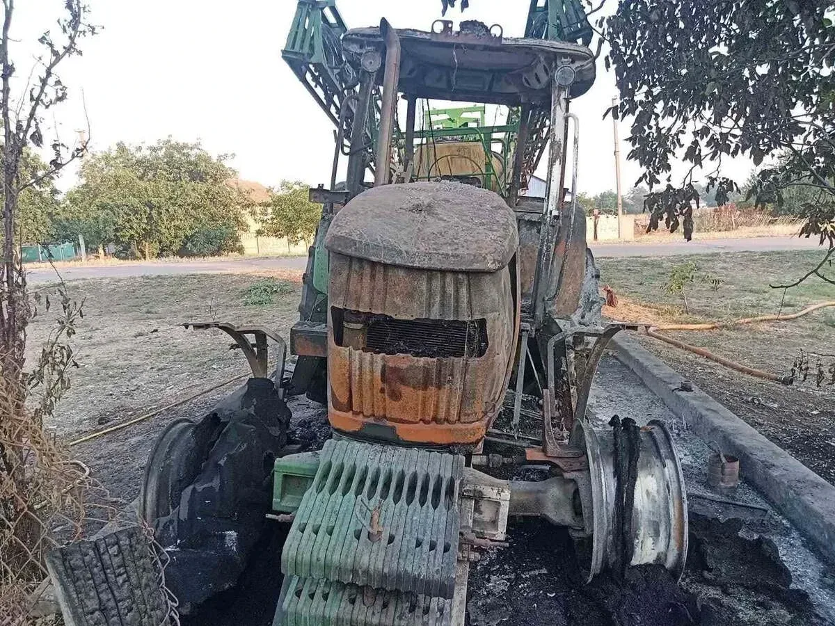 Згорілий трактор John Deere на фермерській базі після атаки російського дрона в Бериславському районі 2