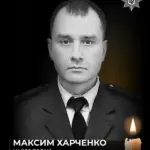 Свічка пам'яті та поліцейський жетон, символізуючи загиблого майора поліції Максима Харченка в ДТП у Херсоні.