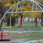 Дитина грається на тлі зруйнованих будівель у Херсоні, символізуючи ситуацію з дітьми в місті