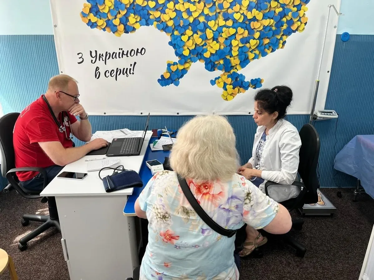 Лікар Червоного Хреста консультує переселенця з Херсонщини під час медичного огляду у Хмельницькому 1