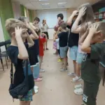 Волонтери з різних країн грають з дітьми та дарують їм подарунки у херсонській бібліотеці, створюючи радісну атмосферу.