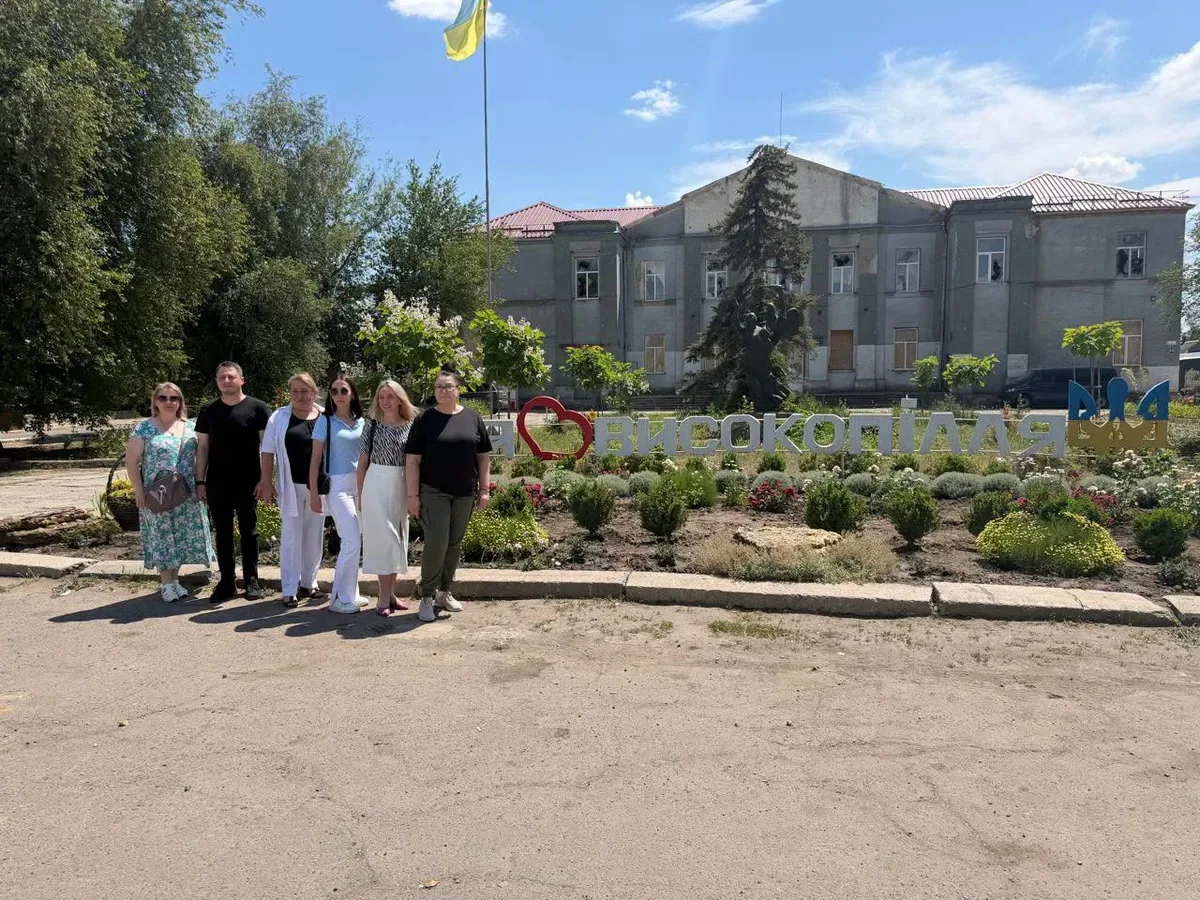 Жінка в розмові з іншими учасниками заходу, що присвячений ментальному здоров'ю в громадах. 2