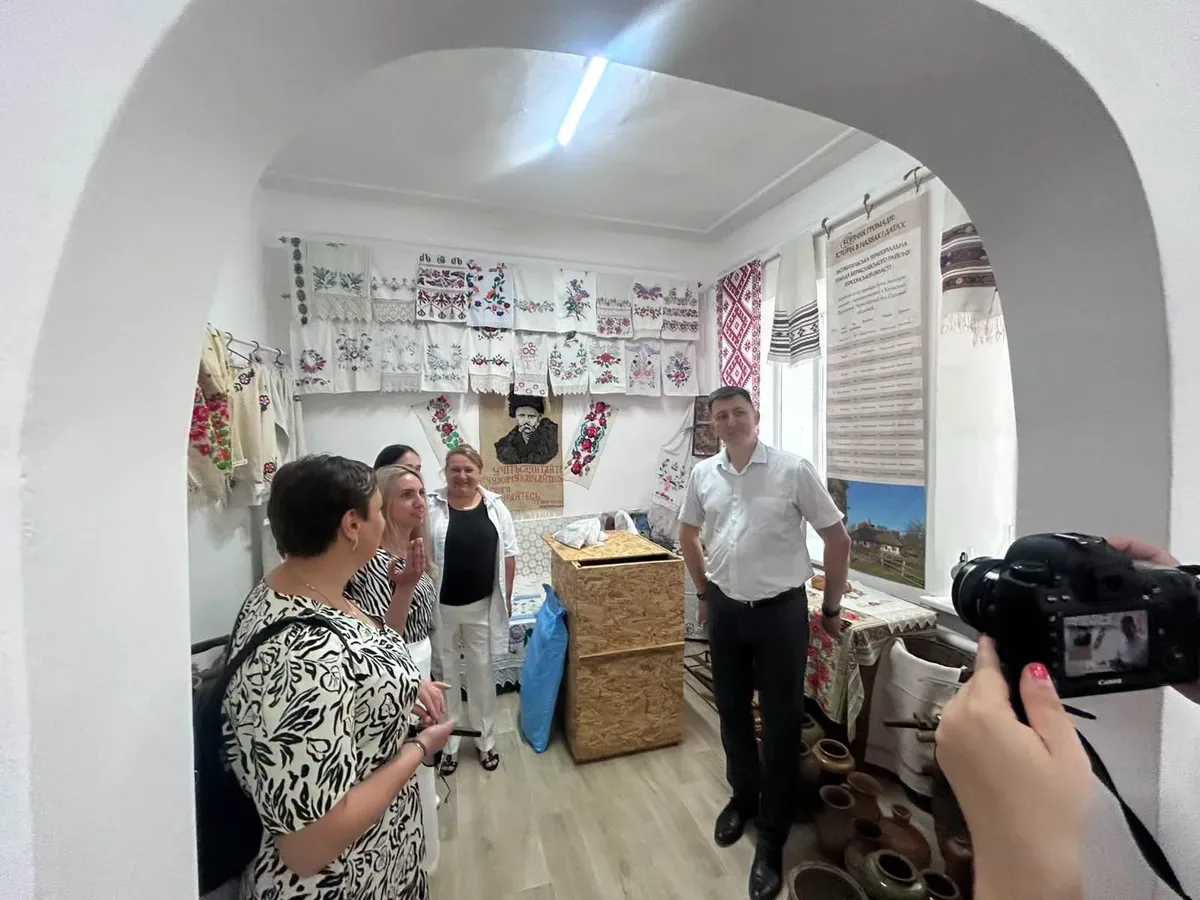 Жінка в розмові з іншими учасниками заходу, що присвячений ментальному здоров'ю в громадах. 3