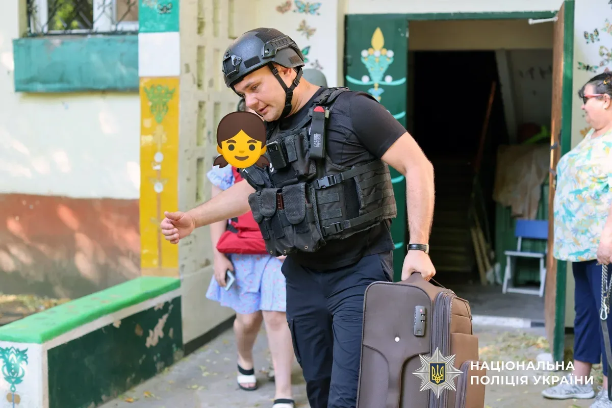 Поліцейські та волонтери евакуюють матір з двома доньками з небезпечного району Херсона на броньованому автомобілі. 4