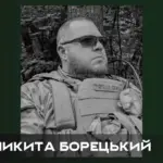Свічка пам'яті та квіти біля фотографії загиблого військового Микити Борецького з Нової Каховки