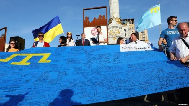 На админгранице с Крымом активисты развернули крымскотатарский флаг, с которым объехали мир
