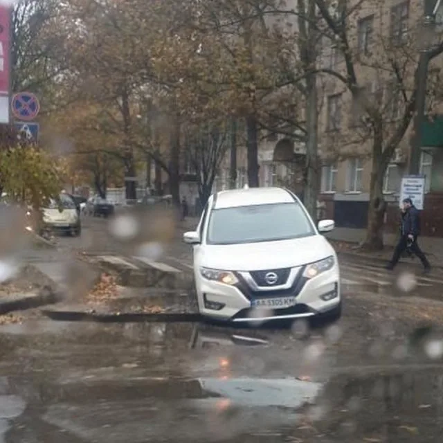 В центре Херсона внедорожник провалился в яму на проезжей части