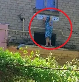В центре Херсона сняли странную старушку, которая общалась по телефону стоя на подъездном козырьке